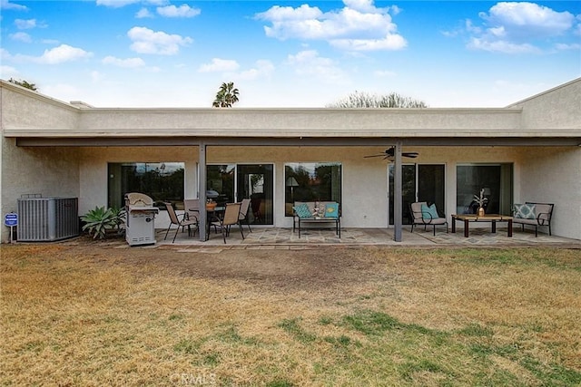 rear view of property with a patio, a yard, central AC, and ceiling fan