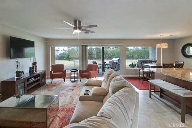 living room with a healthy amount of sunlight, light tile patterned floors, and ceiling fan