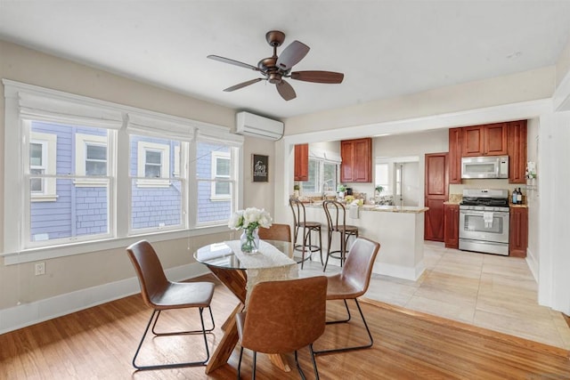 dining area with a wall mounted air conditioner, plenty of natural light, ceiling fan, and light wood-type flooring