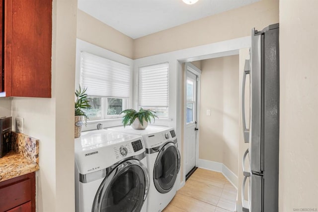 clothes washing area featuring light tile patterned flooring and washing machine and dryer