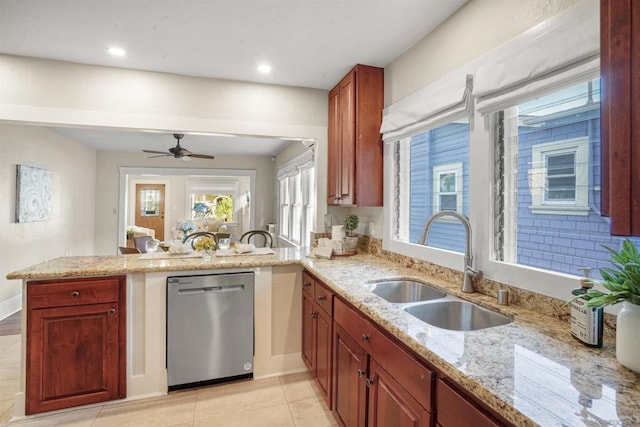 kitchen with sink, light tile patterned floors, stainless steel dishwasher, light stone counters, and kitchen peninsula