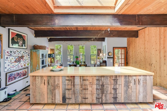 kitchen with butcher block countertops, wooden ceiling, beam ceiling, and wood walls