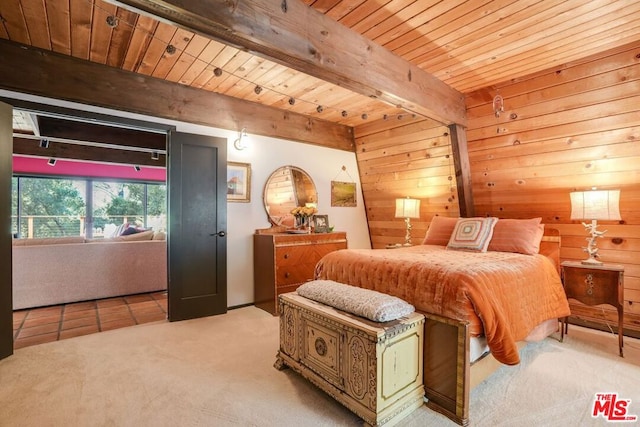 carpeted bedroom with beam ceiling and wood walls