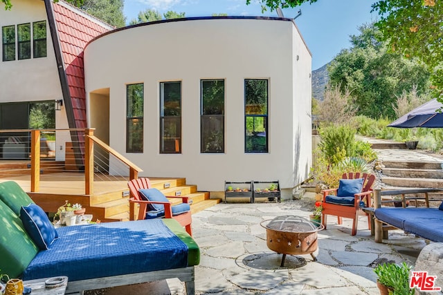 rear view of house featuring a patio and a fire pit