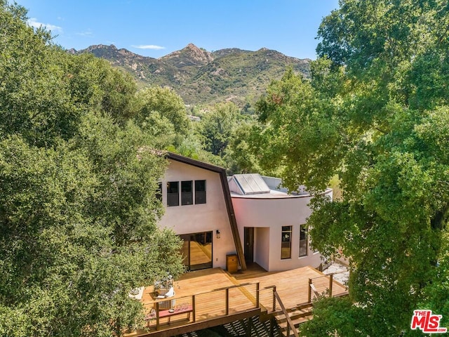 rear view of house with a deck with mountain view