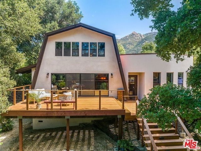 rear view of property featuring a deck with mountain view