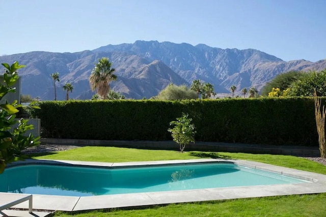 view of pool with a yard and a mountain view