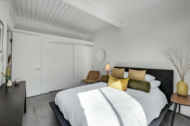 bedroom with beamed ceiling, wooden ceiling, and a closet