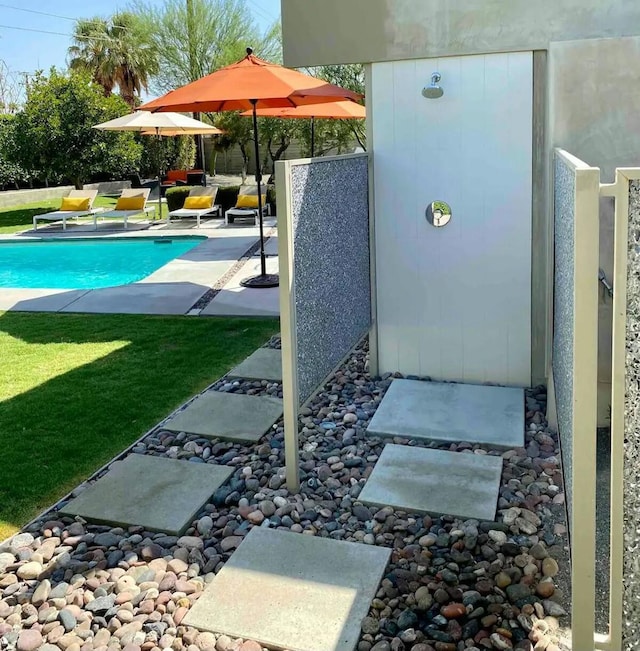 view of swimming pool featuring a lawn and a patio area