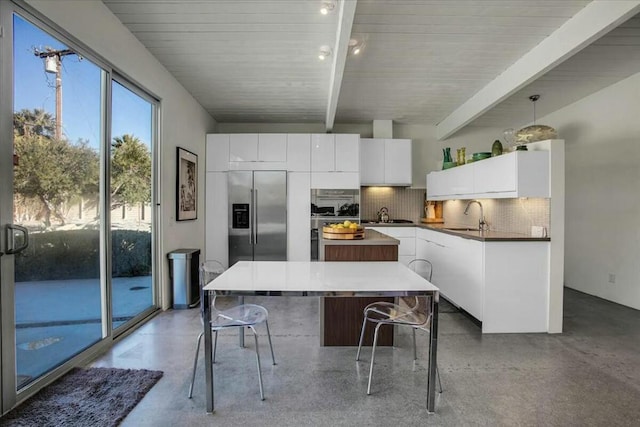 kitchen with stainless steel built in fridge, sink, white cabinets, and decorative backsplash