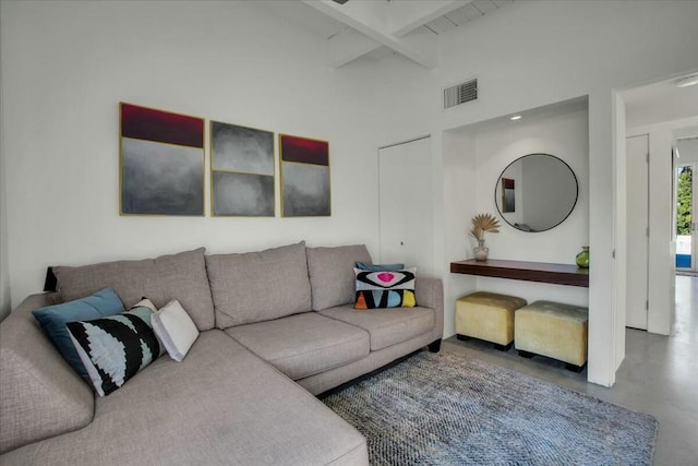 living room with a towering ceiling, concrete flooring, and beam ceiling