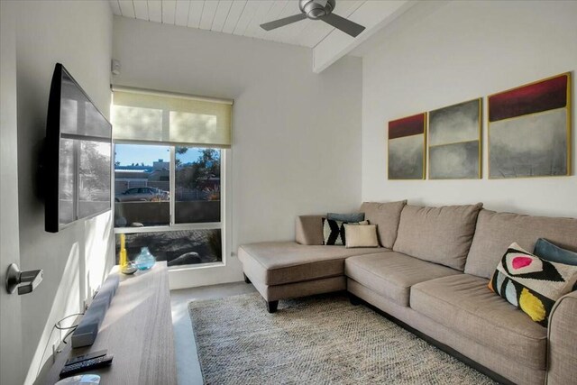 living room featuring ceiling fan and beamed ceiling