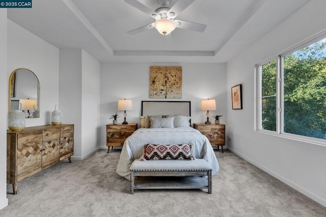 bedroom featuring ceiling fan, a raised ceiling, and carpet floors