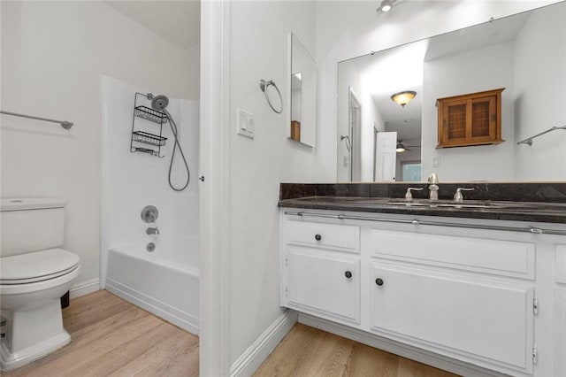 full bathroom with wood-type flooring, bathing tub / shower combination, vanity, and toilet