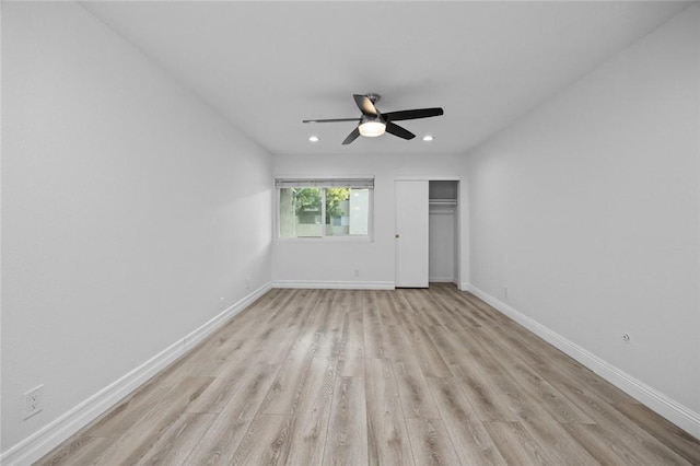 unfurnished bedroom with light hardwood / wood-style flooring, a closet, and ceiling fan