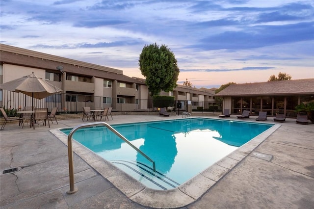 pool at dusk with a patio