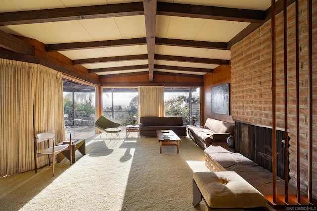 sunroom with an outdoor brick fireplace and lofted ceiling with beams