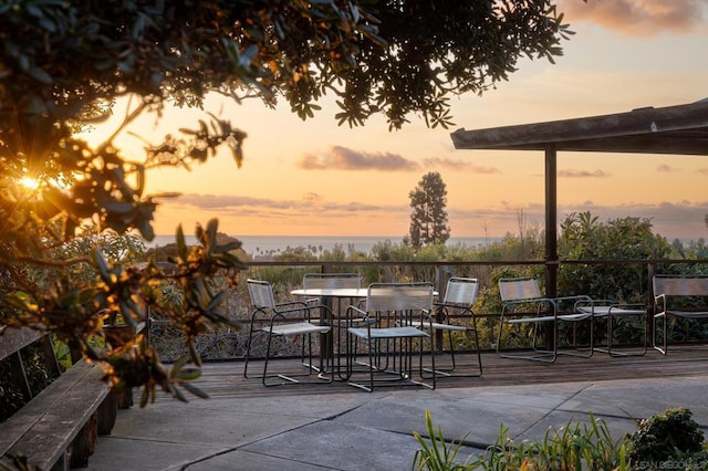 patio terrace at dusk featuring a water view