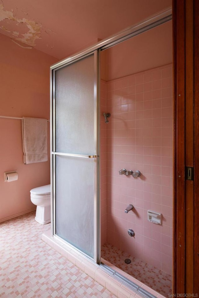 bathroom with toilet and a shower with shower door