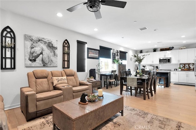 living room featuring ceiling fan and light hardwood / wood-style floors