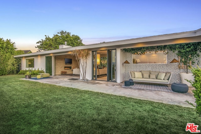 back of property featuring a lawn and a patio area