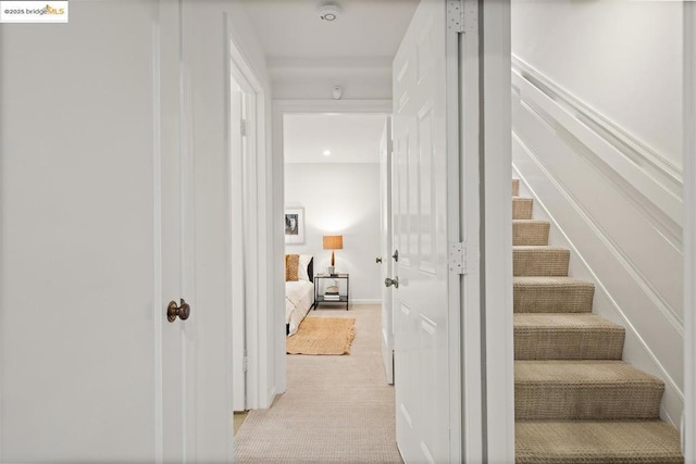 hall with light colored carpet