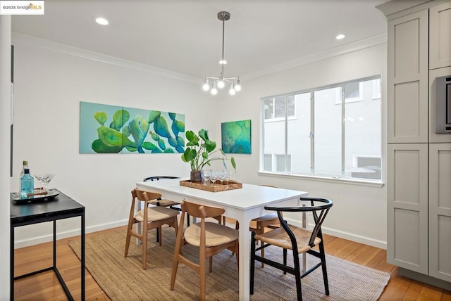 dining area featuring crown molding, a chandelier, and light hardwood / wood-style floors