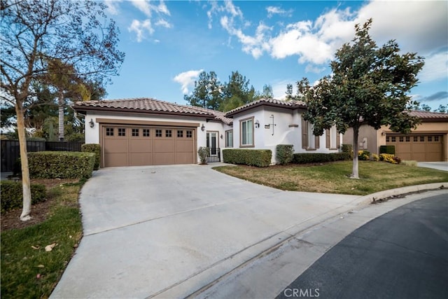 mediterranean / spanish house with a garage and a front yard