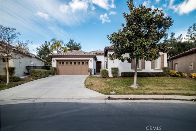 mediterranean / spanish house with a garage and a front lawn