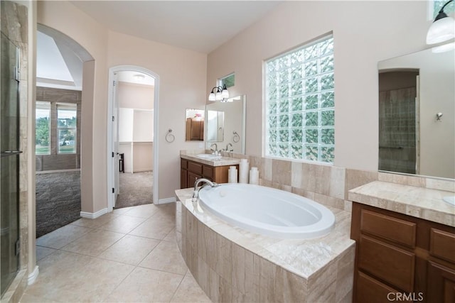 bathroom featuring vanity, shower with separate bathtub, and tile patterned floors