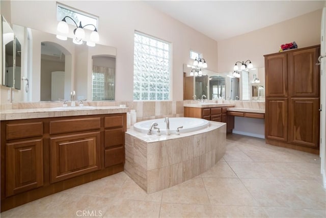 bathroom featuring a relaxing tiled tub, tile patterned floors, and vanity