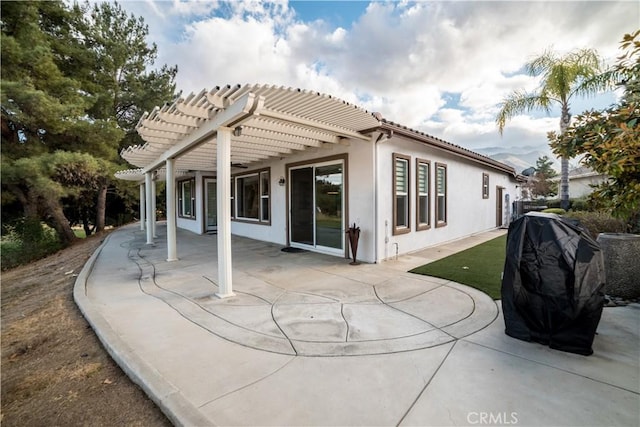 rear view of property featuring a patio and a pergola