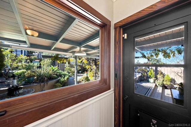 doorway to outside with beamed ceiling