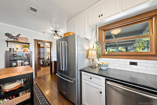 kitchen featuring tasteful backsplash, white cabinets, ceiling fan, stainless steel appliances, and dark wood-type flooring