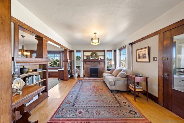 living room with a fireplace and light wood-type flooring