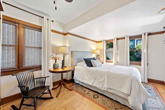 bedroom featuring ornamental molding and light hardwood / wood-style flooring