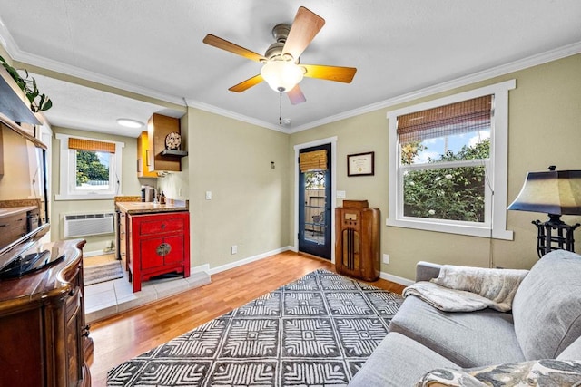 living room featuring crown molding, wood-type flooring, a wall unit AC, and ceiling fan