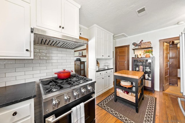 kitchen with gas range, wooden counters, ventilation hood, light hardwood / wood-style flooring, and white cabinets