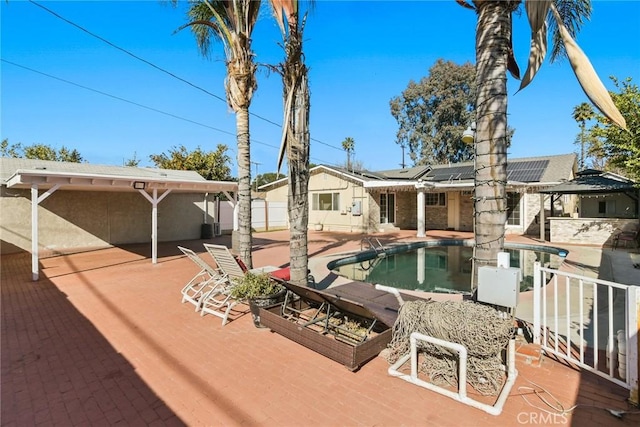 rear view of house with a patio and solar panels