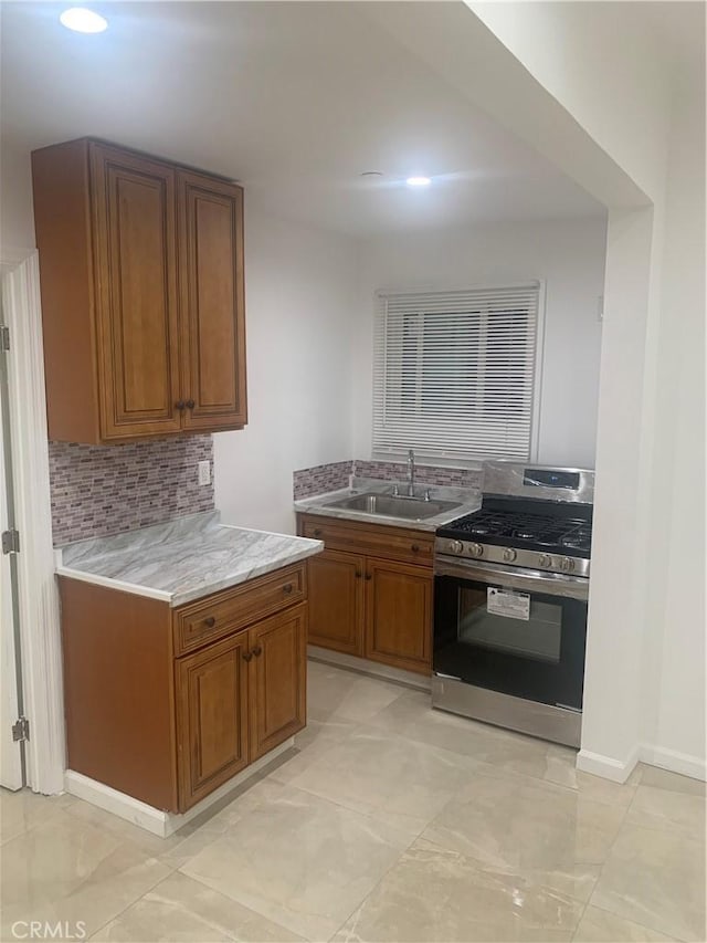 kitchen featuring tasteful backsplash, sink, and gas range