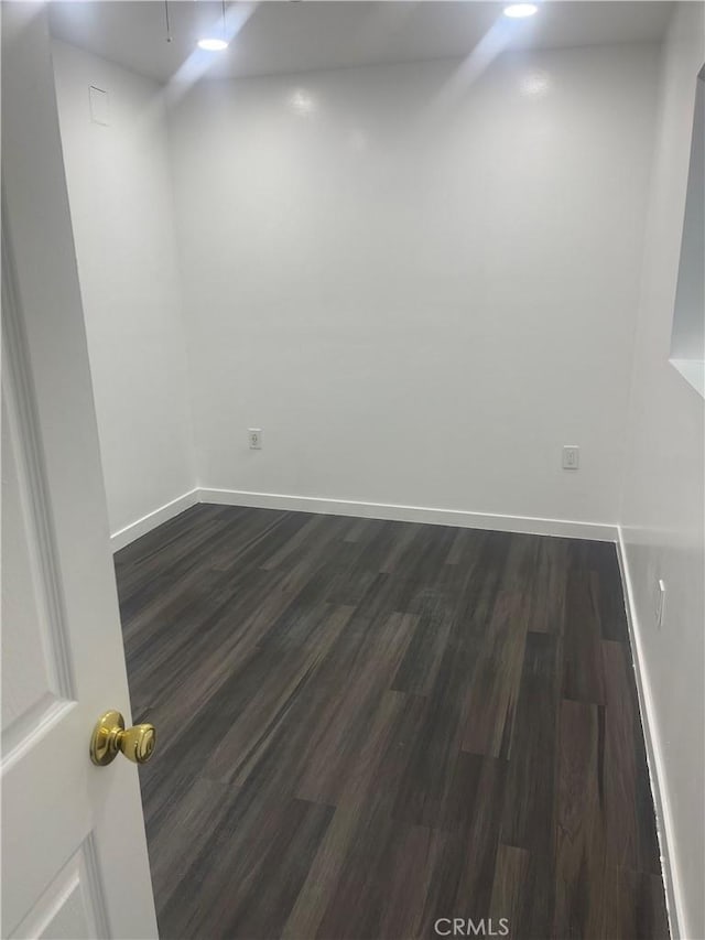 empty room with dark hardwood / wood-style flooring