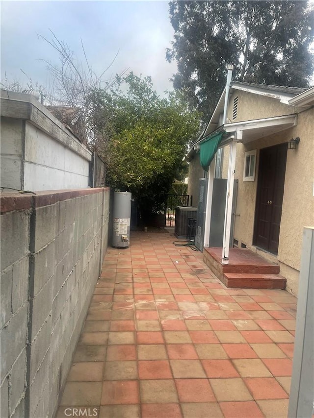 view of patio with cooling unit and water heater