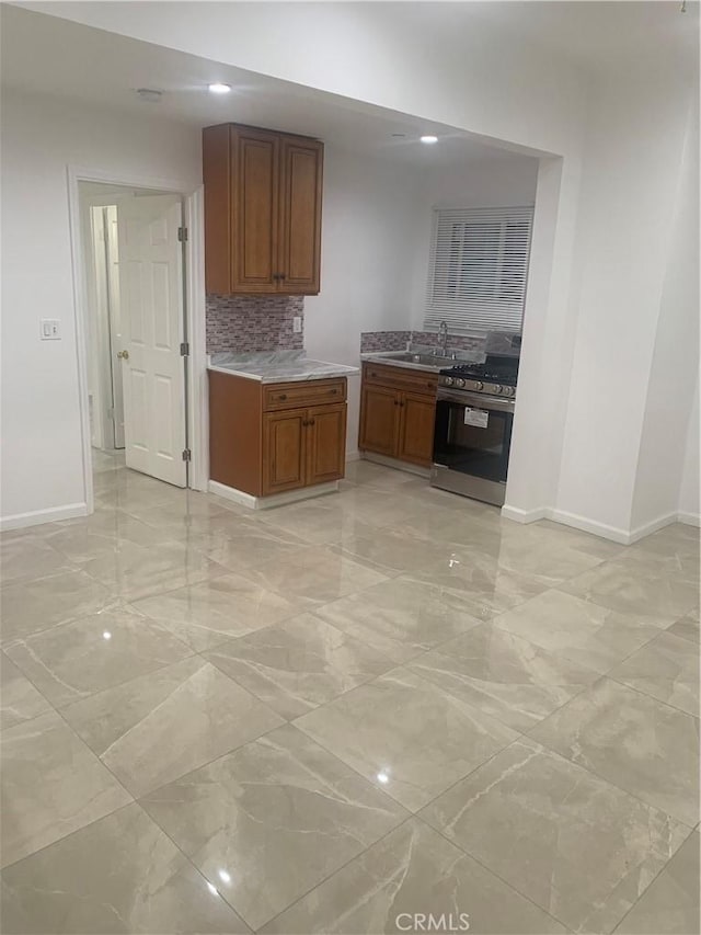 kitchen featuring gas range and backsplash