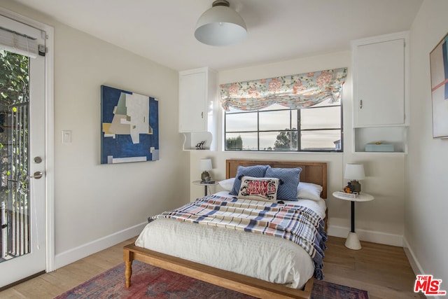 bedroom with access to exterior and light hardwood / wood-style floors