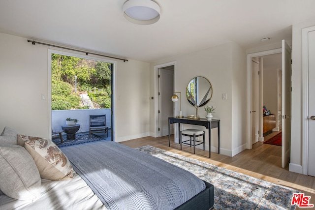 bedroom with access to exterior and light wood-type flooring