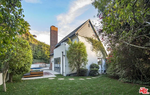 rear view of property with a patio and a lawn