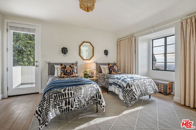 bedroom with multiple windows, access to exterior, and light hardwood / wood-style flooring