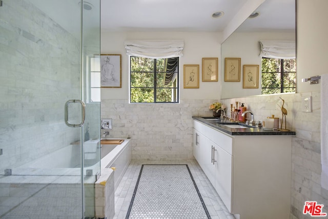 bathroom with tile walls, a tub to relax in, tile patterned flooring, and vanity