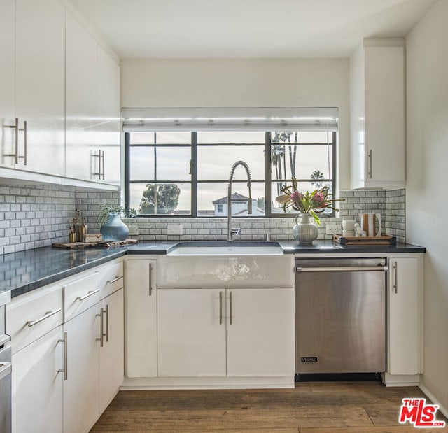 kitchen with sink, stainless steel dishwasher, dark hardwood / wood-style floors, and white cabinets