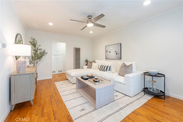 living room with crown molding, ceiling fan, and light hardwood / wood-style floors